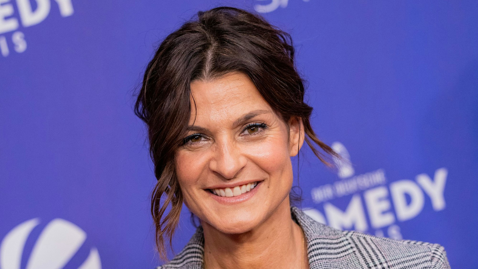 Marlene blickt lächelnd in die Kamera. Sie trägt einen blauen Blazer.
