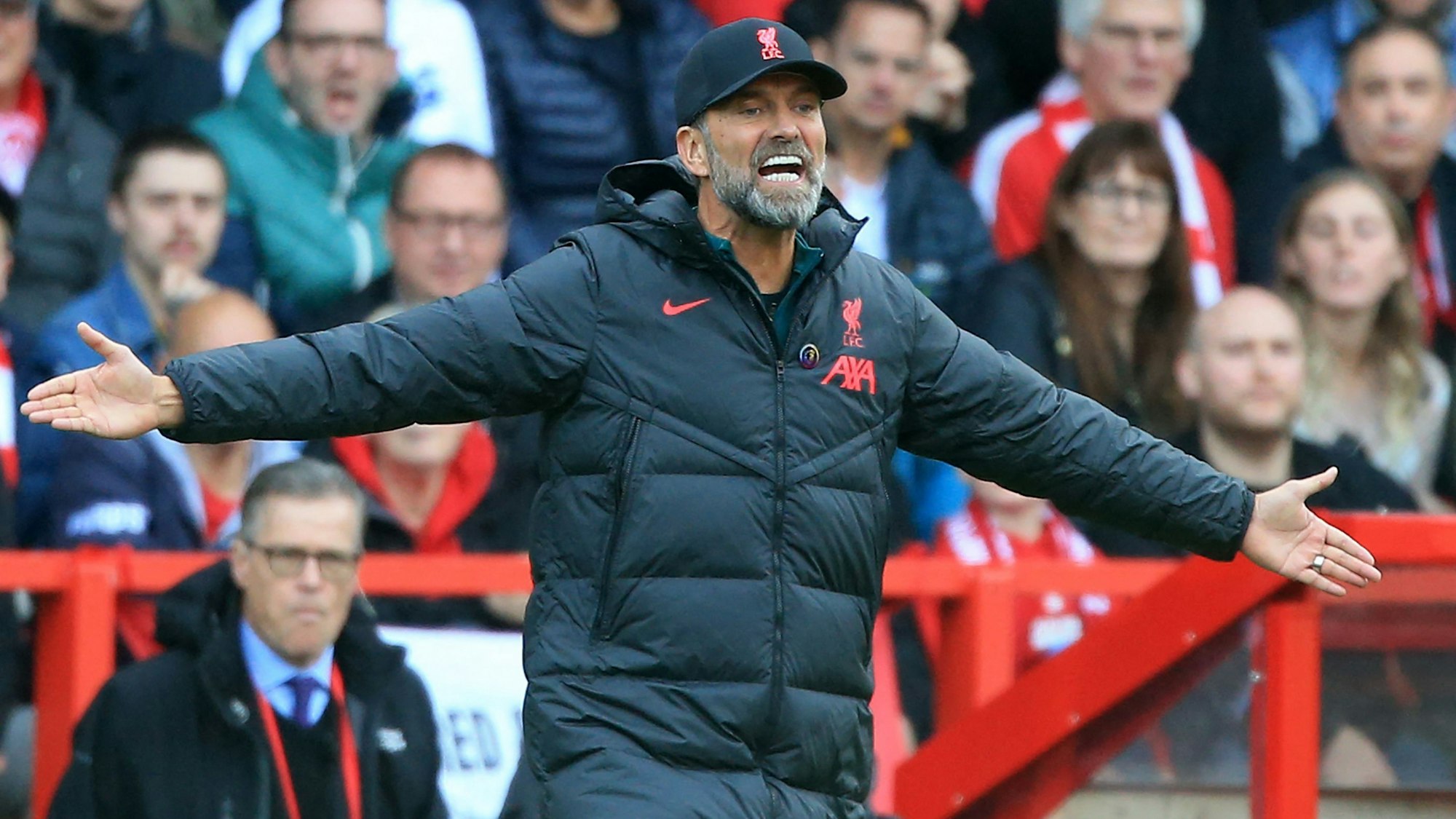 Jürgen Klopp gestikuliert mit weit ausgestreckten Armen in Richtung seiner Mannschaft.