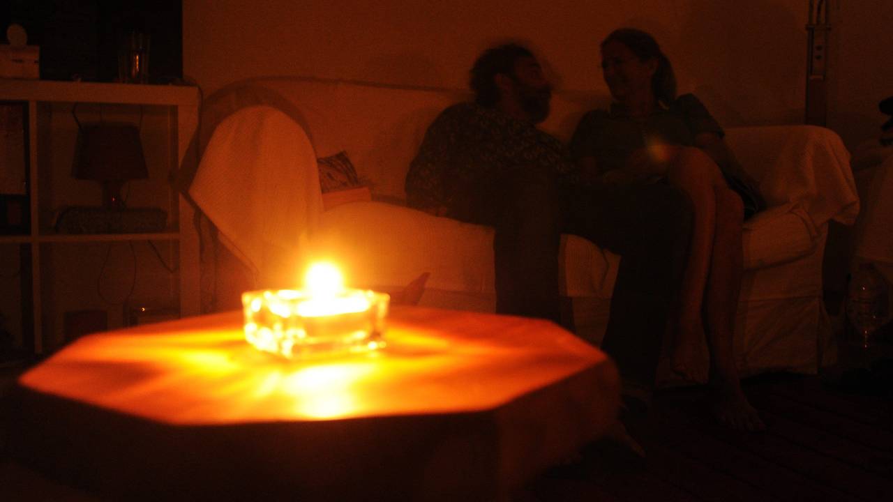 Ein Paar sitzt während eines Stromausfalls bei Kerzenschein in einer Wohnung in Hannover. In Bayern laufen derzeit die Planungen für einen großflächigen und langanhaltenden Stromausfall, einen sogenannten Blackout.