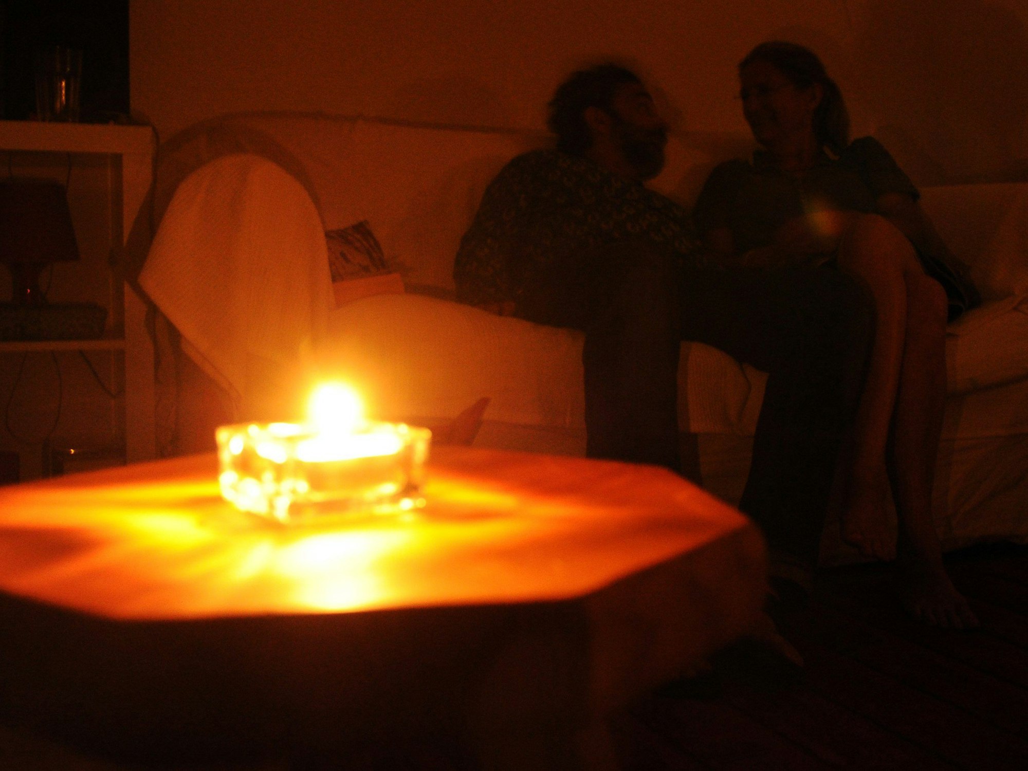 Ein Paar sitzt während eines Stromausfalls bei Kerzenschein in einer Wohnung in Hannover. In Bayern laufen derzeit die Planungen für einen großflächigen und langanhaltenden Stromausfall, einen sogenannten Blackout.