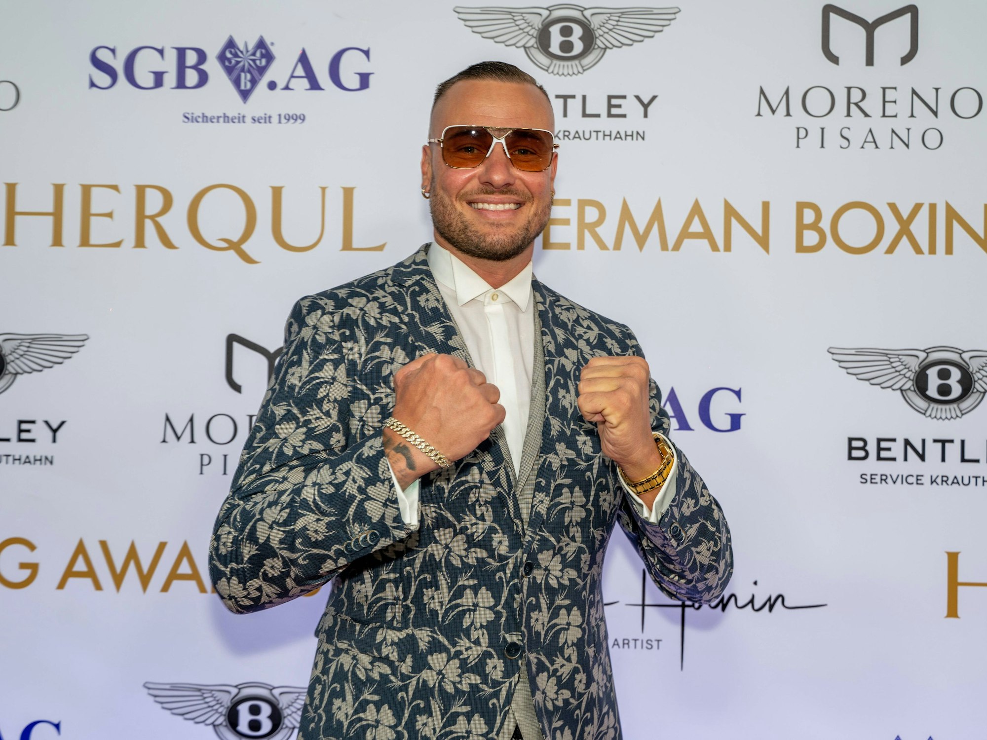 Das Foto zeigt Reality-Darsteller Eric Sindermann bei einer Preisverleihung in Berlin, wo er mit geballten Fäusten posiert.