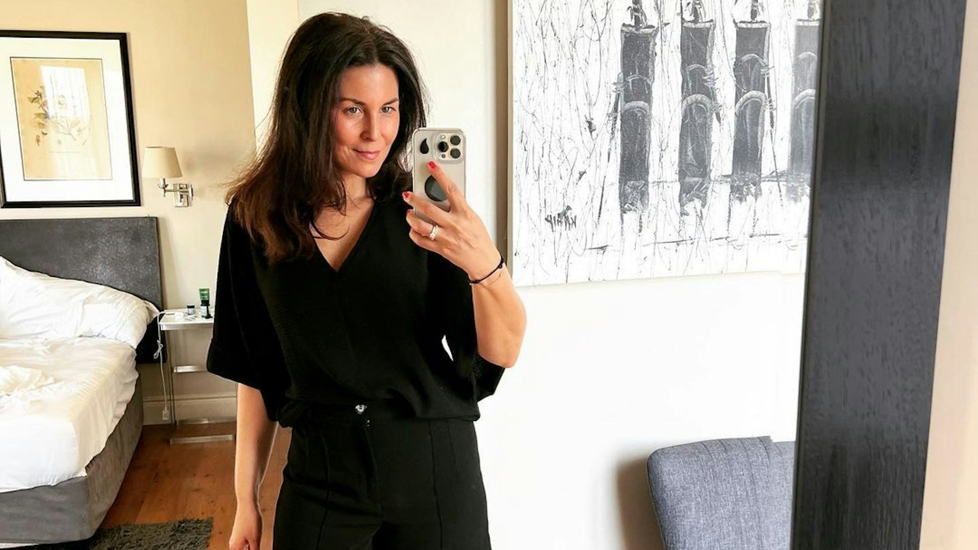 Vanessa posiert vor einem Hotelzimmer-Spiegel für ein Selfie.
