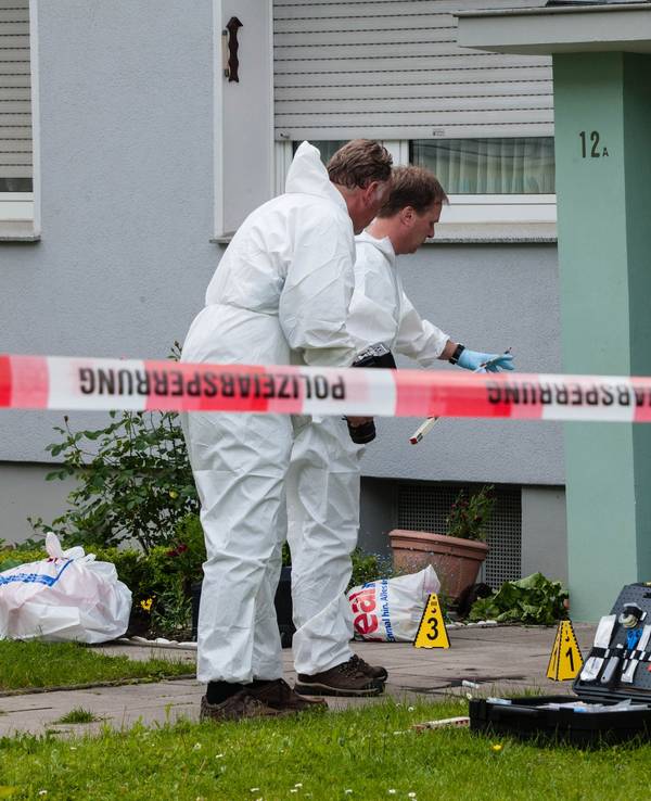 Beamte der Spurensicherung arbeiten vor einem Haus mit ihrem Equipment.