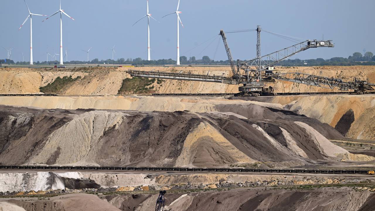 Ein Schaufelradbagger arbeitet im Braunkohletagebau Garzweiler. Im Hintergrund sind Windräder zu sehen. Das Foto stammt aus dem September 2022.