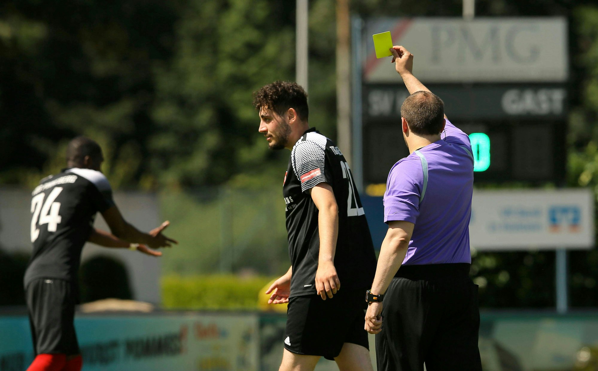 Ein Schiedsrichter zeigt die Gelbe Karte.