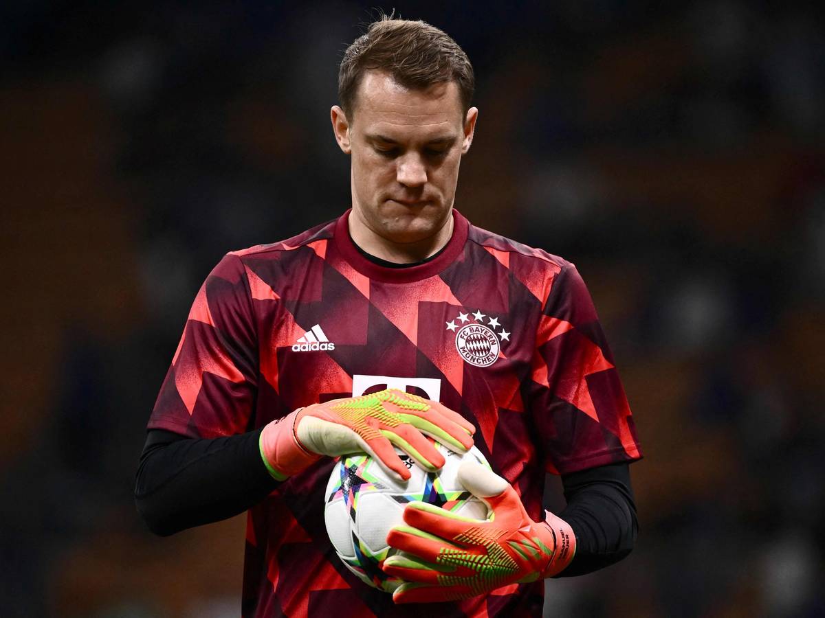 Manuel Neuer hält einen Fußball in seinen Händen.