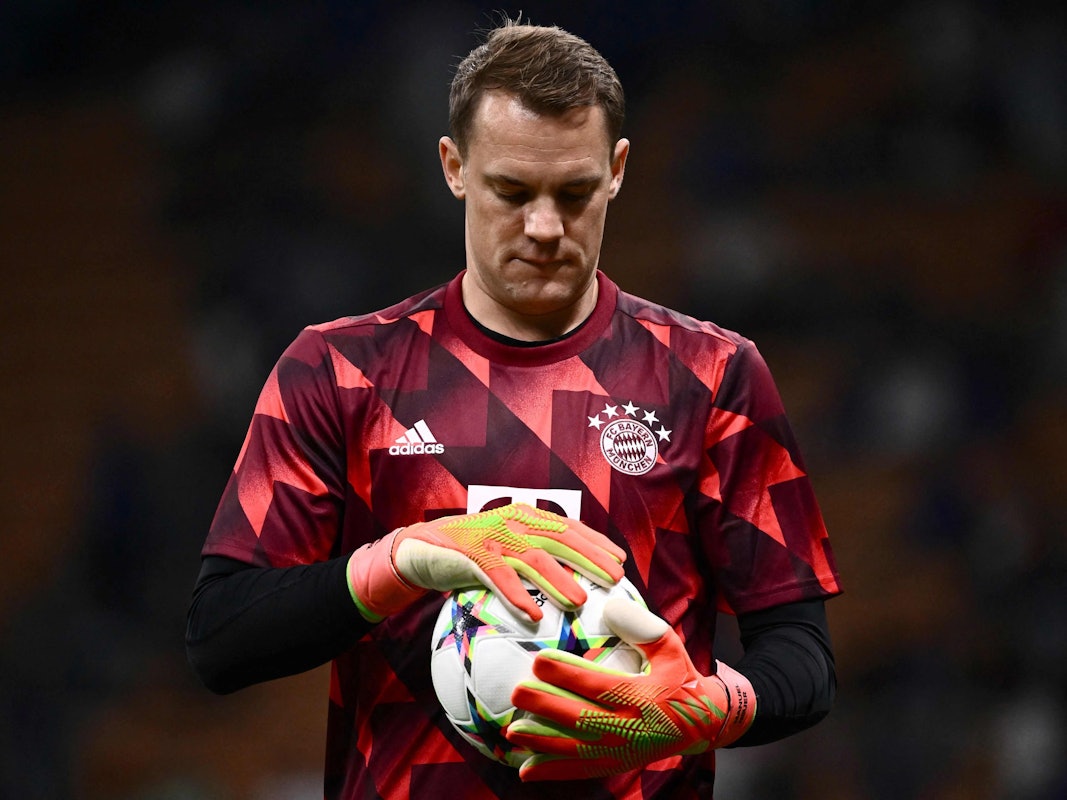 Manuel Neuer hält einen Fußball in seinen Händen.