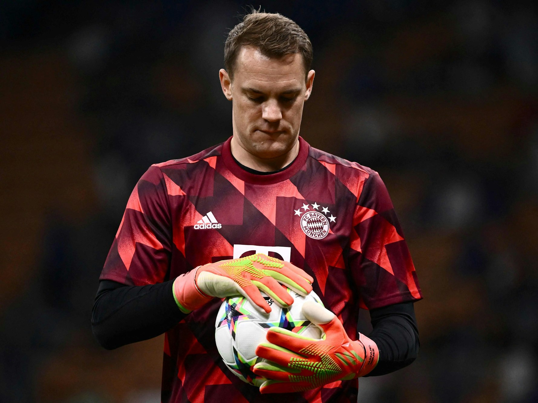 Manuel Neuer hält einen Fußball in seinen Händen.
