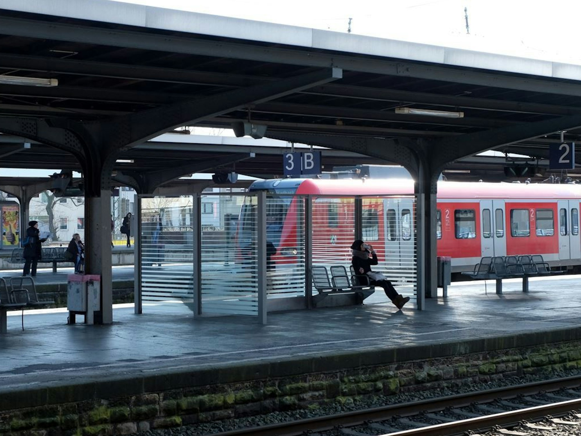 Menschen gehen über einen Bahnsteig am Bahnhof in Köln-Mülheim.
