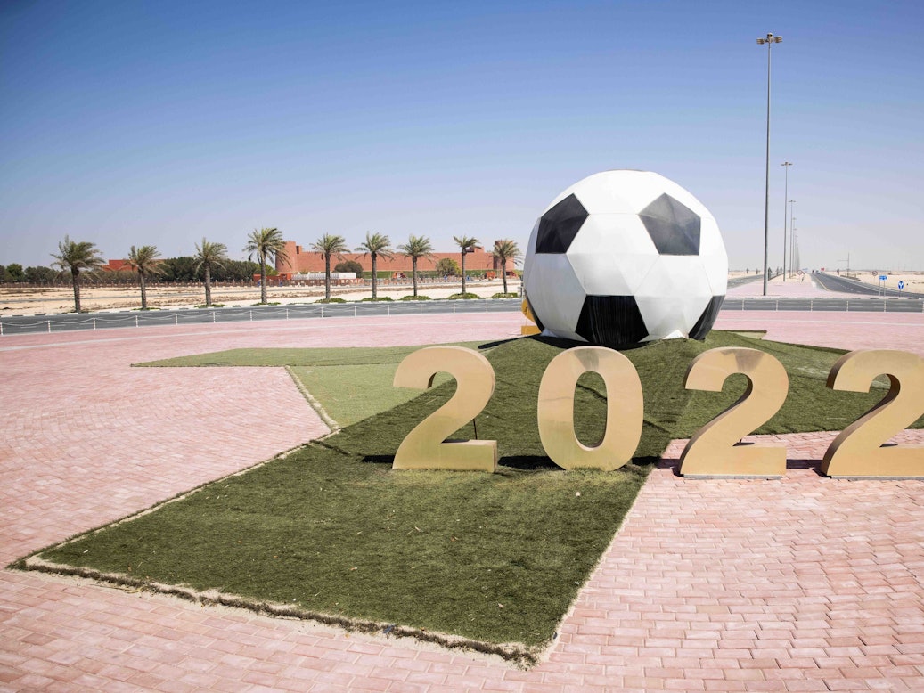Ein großer Ball mit der Jahreszahl 2022 steht auf einer Verkehrsinsel mit Kreisverkehr vor dem Trainigsgelände Al-Shamal sports Club in der Hafenstadt Al Ruwais.