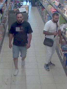 Zwei Männer laufen durch einen Supermarkt.