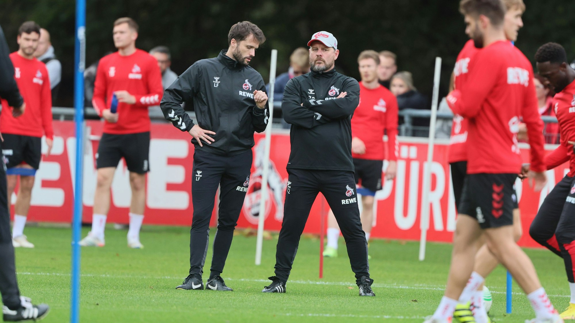 Leif Frach spricht mit Steffen Baumgart während des FC-Trainings.