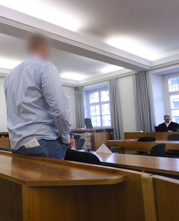 Mann steht in der Anklagebank in einem Verhandlungsraum. Er soll eine Kollegin bei einem Bundeswehr-Einsatz vergewaltigt haben.