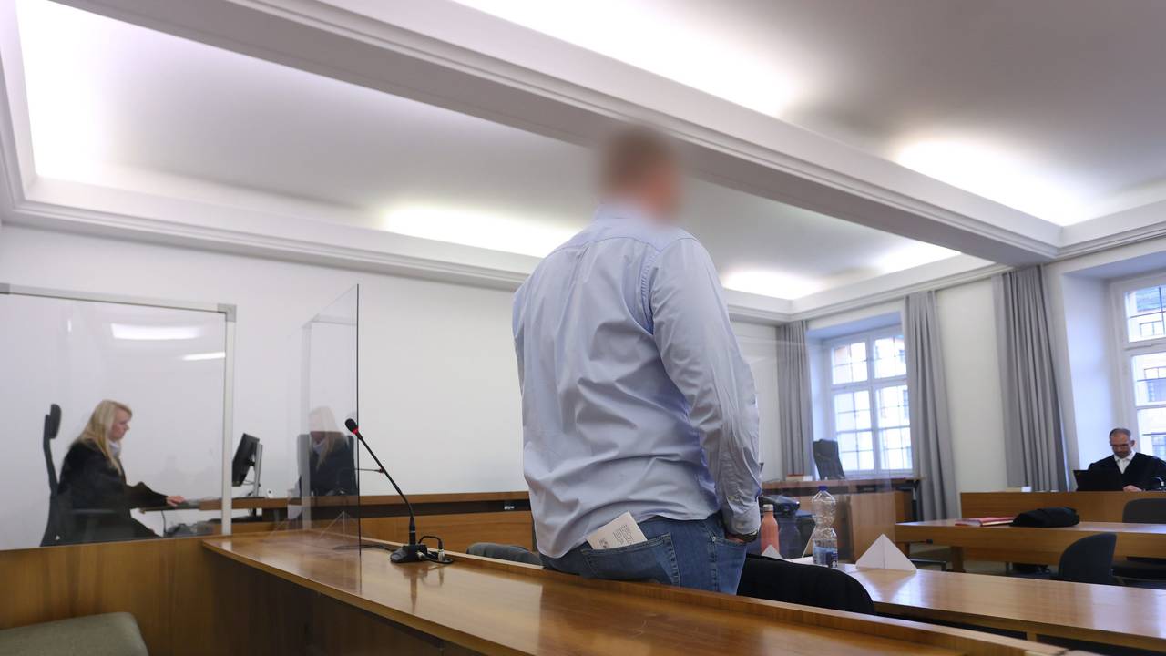 Mann steht in der Anklagebank in einem Verhandlungsraum. Er soll eine Kollegin bei einem Bundeswehr-Einsatz vergewaltigt haben.
