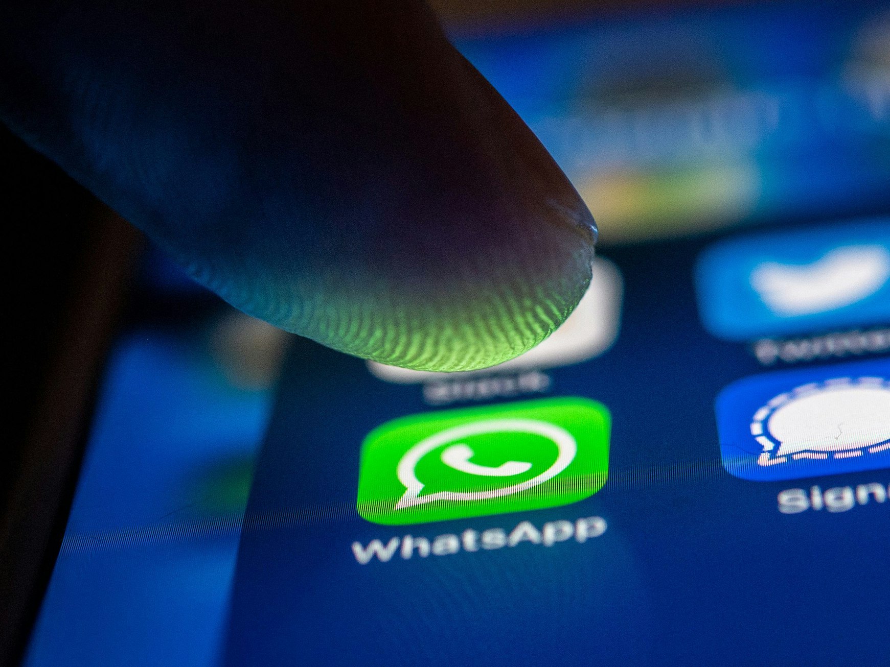 Eine Person tippt auf das WhatsApp-Logo auf ihrem Smartphone.