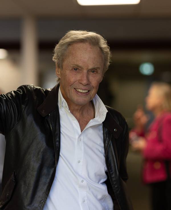 Peter Kraus lehnt lässig in einem Türrahmen.