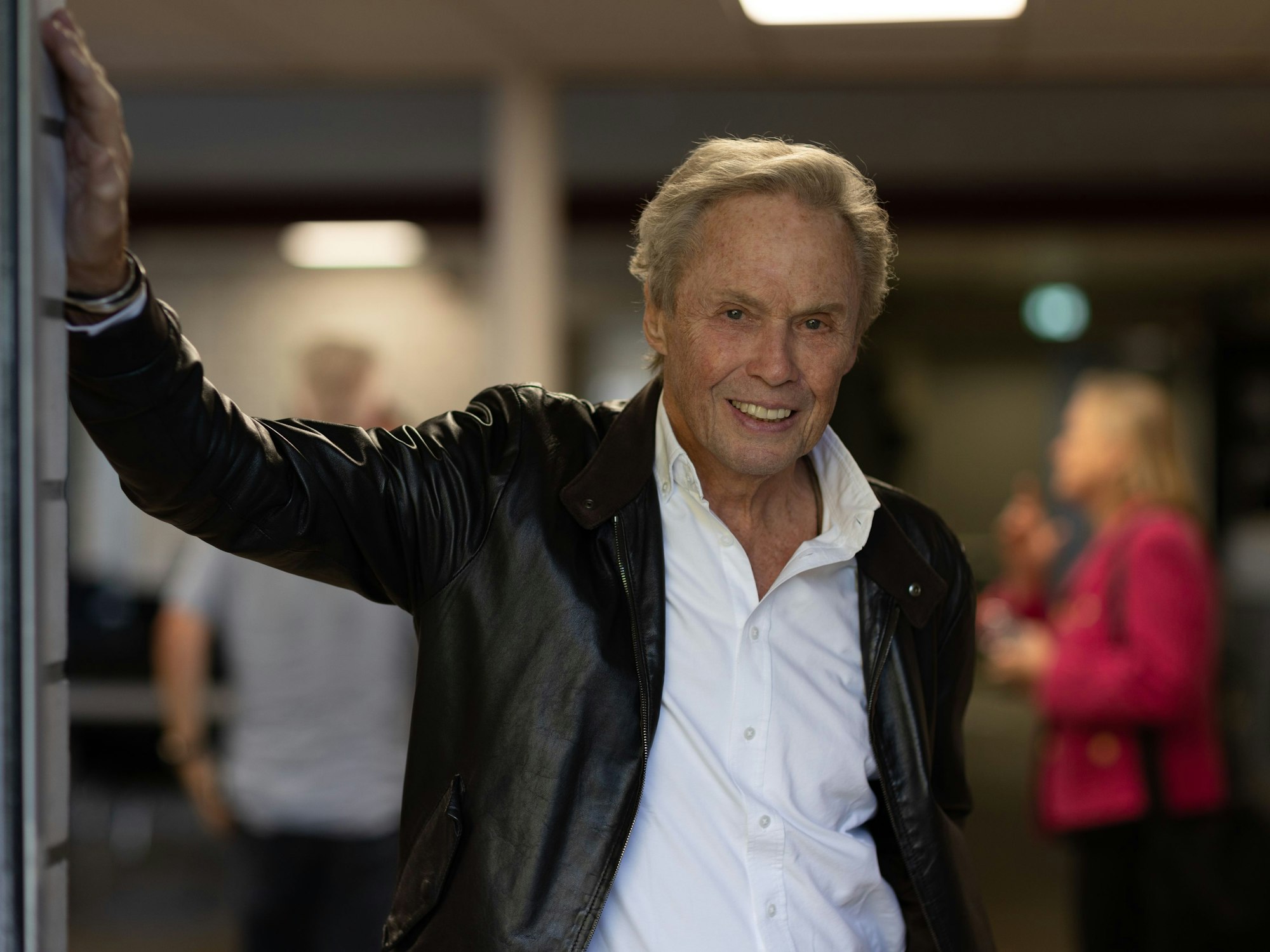 Peter Kraus lehnt lässig in einem Türrahmen.