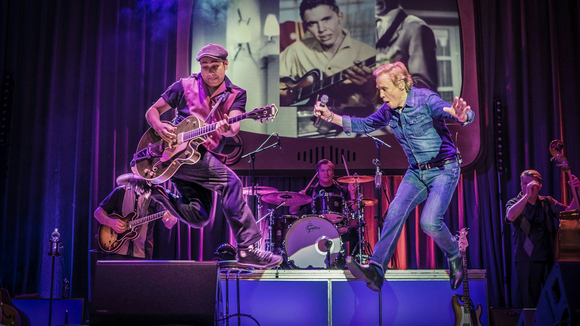Peter Kraus springt bei einem Konzert über die Bühne.