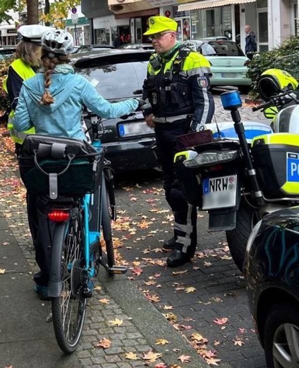 Die Polizei in Wuppertal im Gespräch mit einer Radfahrerin. Nach einem tödlichen Unfall wird der flüchtige Verursacher gesucht.