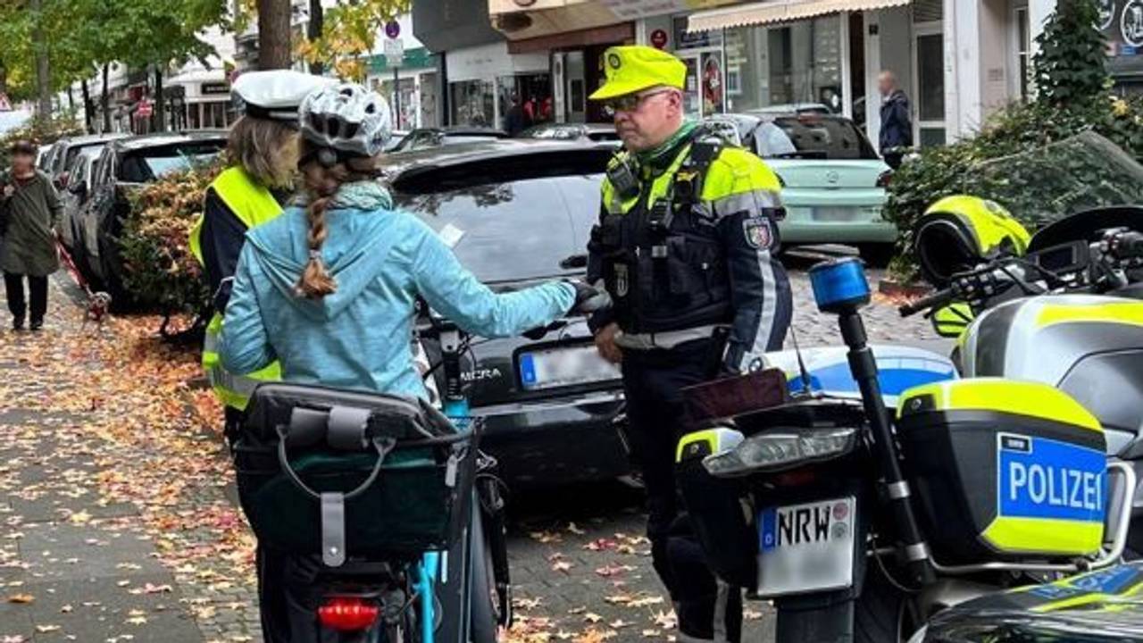 Die Polizei in Wuppertal im Gespräch mit einer Radfahrerin. Nach einem tödlichen Unfall wird der flüchtige Verursacher gesucht.