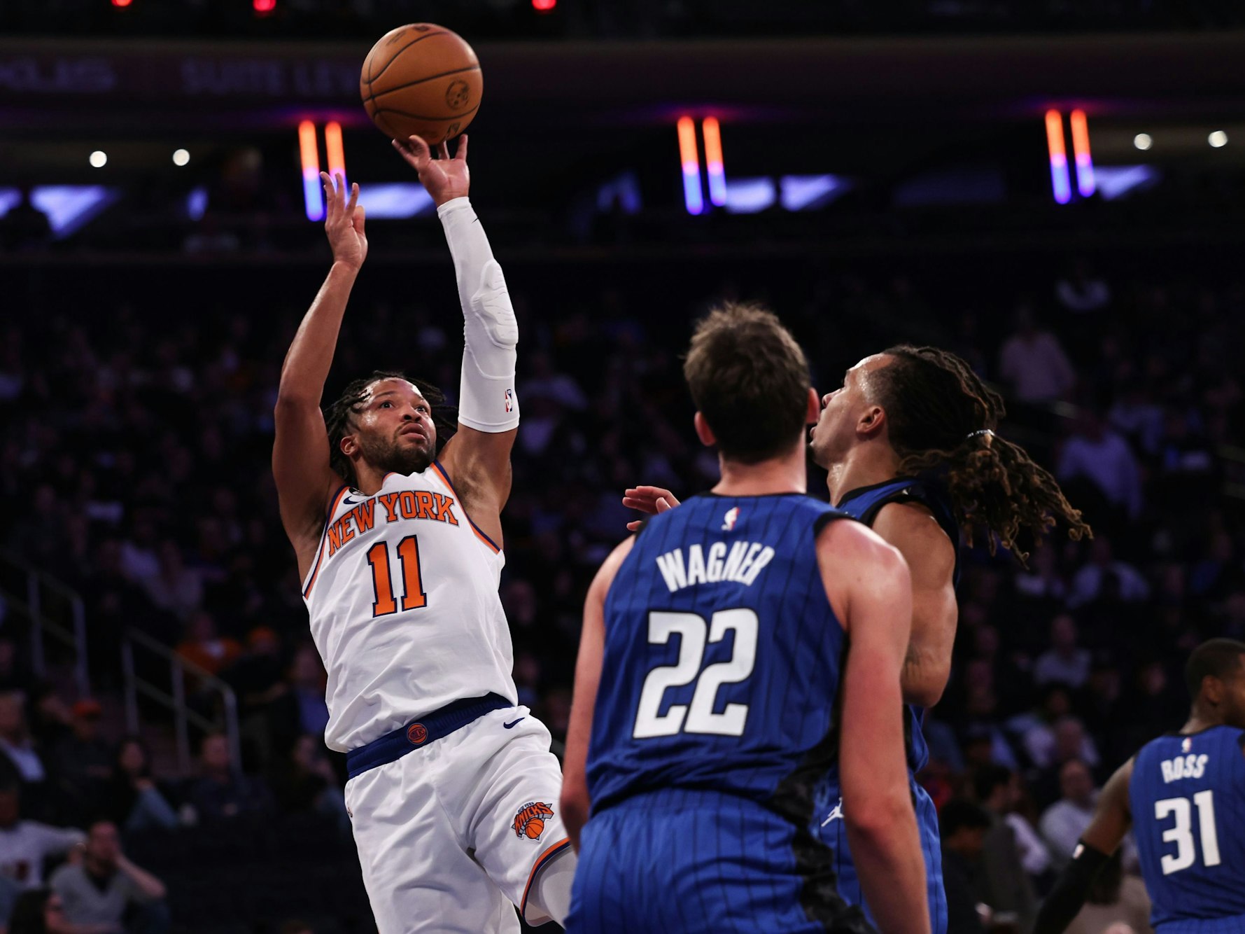 Jalen Brunson (links) setzt zum Wurf an, während Franz Wagner und ein Teamkollege zuschauen.