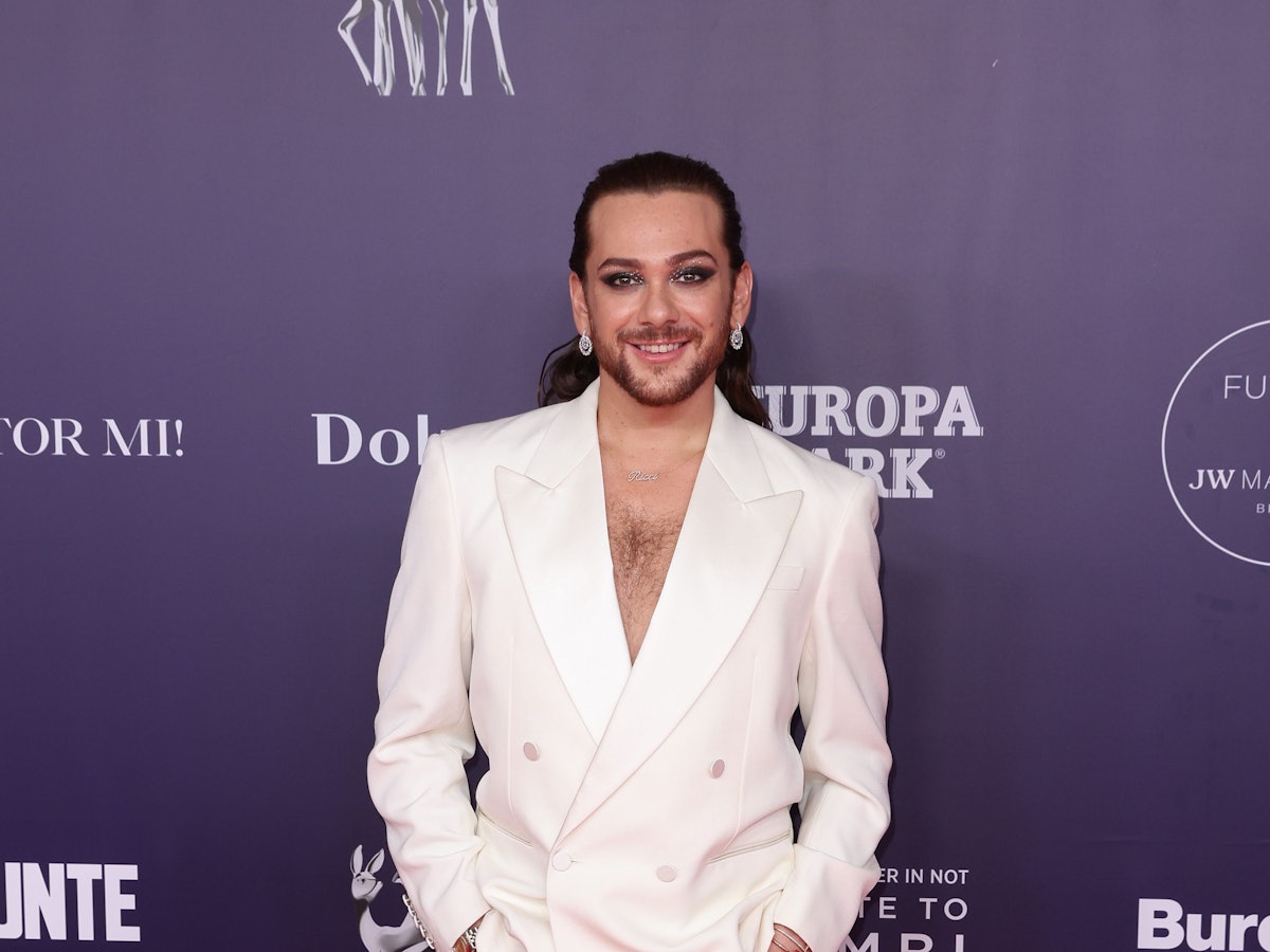 Entertainer Riccardo Simonetti in einem weißen Anzug auf dem roten Teppich.