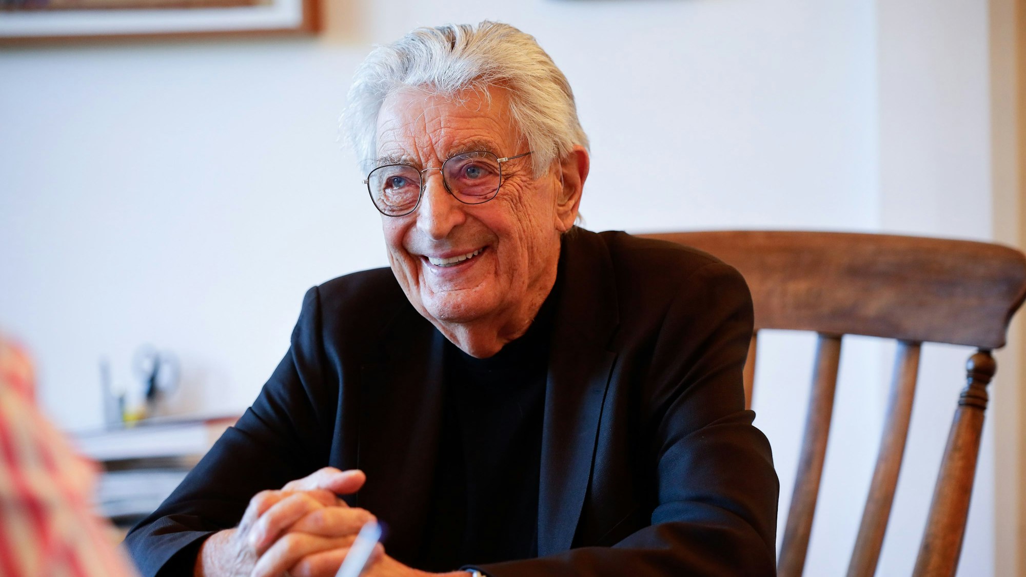 Politiker Gerhart Baum sitzt in seiner Wohnung an einem Tisch.