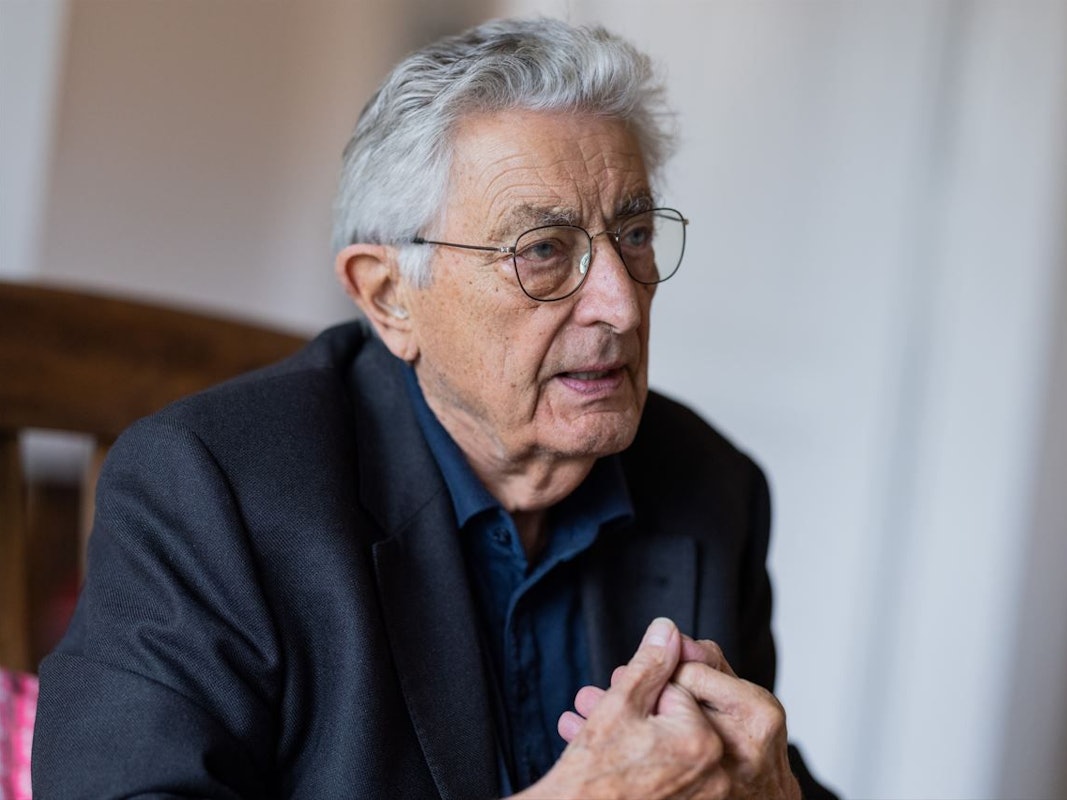 Gerhart Baum sitzt auf einem Stuhl und spricht. Der Ex-Innenminister wird 90 Jahre alt.