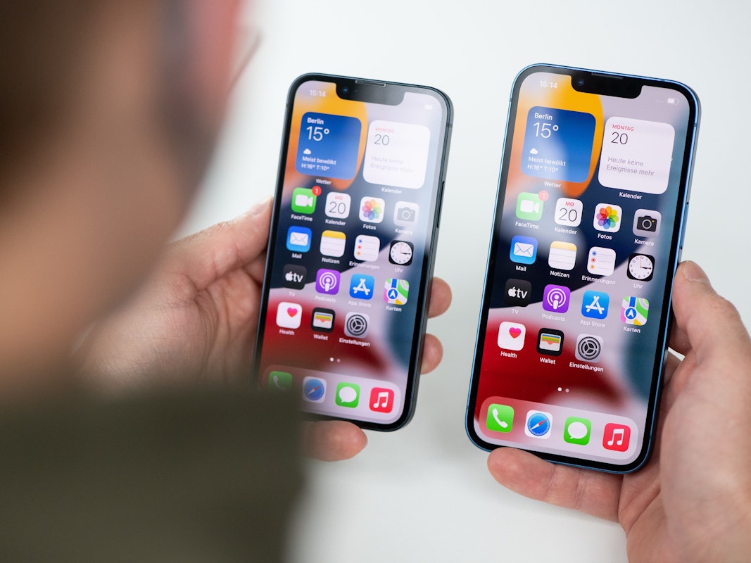 Jemand hält zwei iPhones zum Vergleich in der Hand.