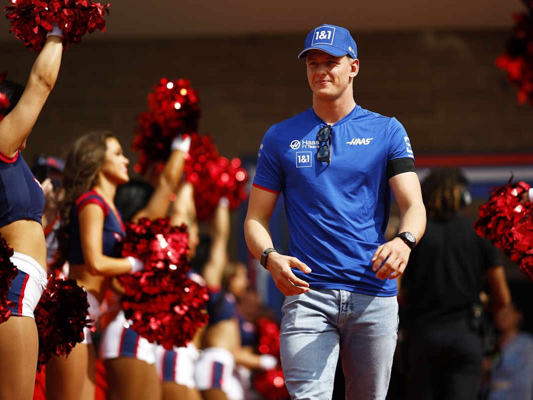 Mick Schumacher zwischen einer Spalier von Cheerleaderinnen.