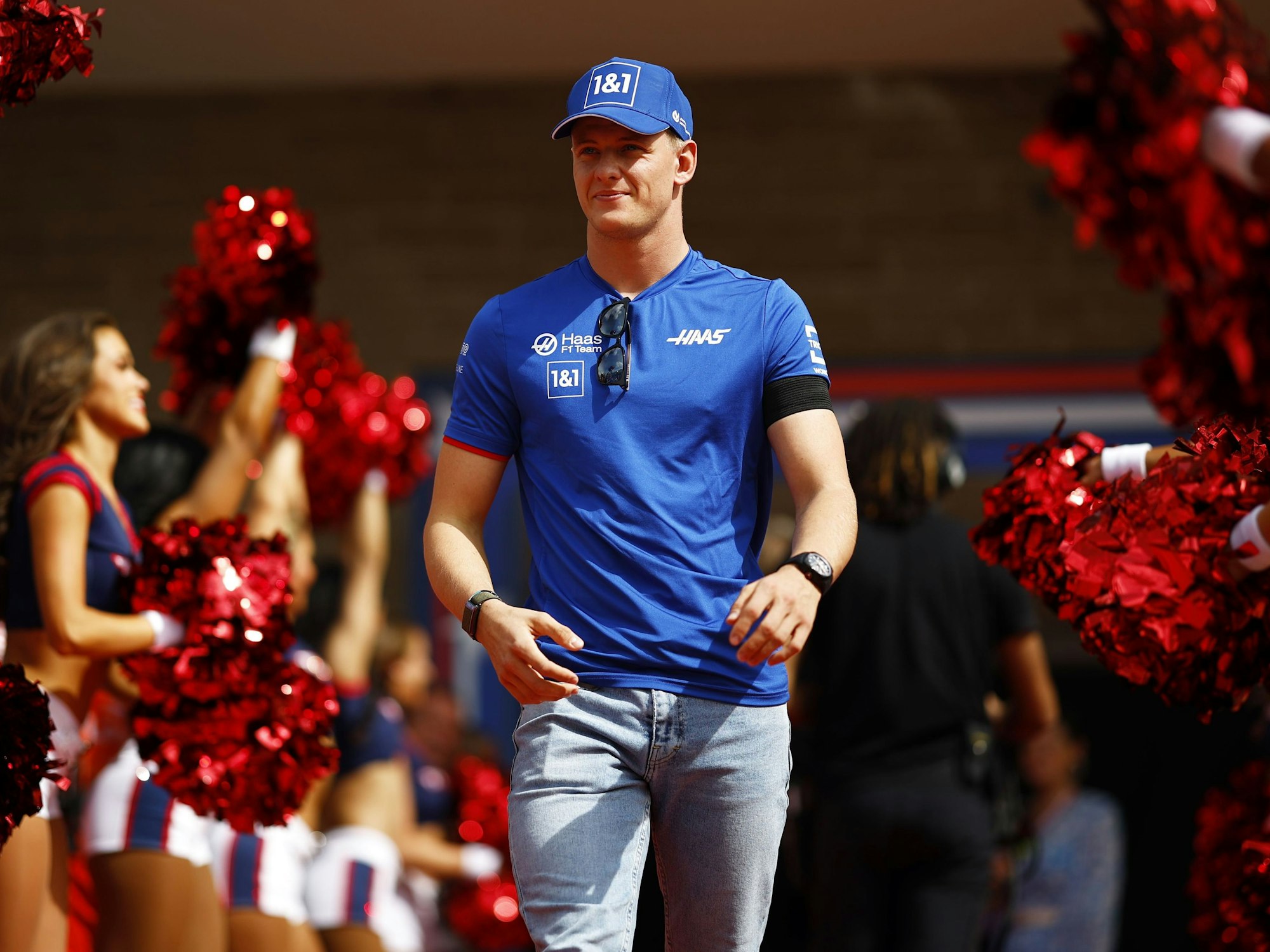 Mick Schumacher zwischen einer Spalier von Cheerleaderinnen.