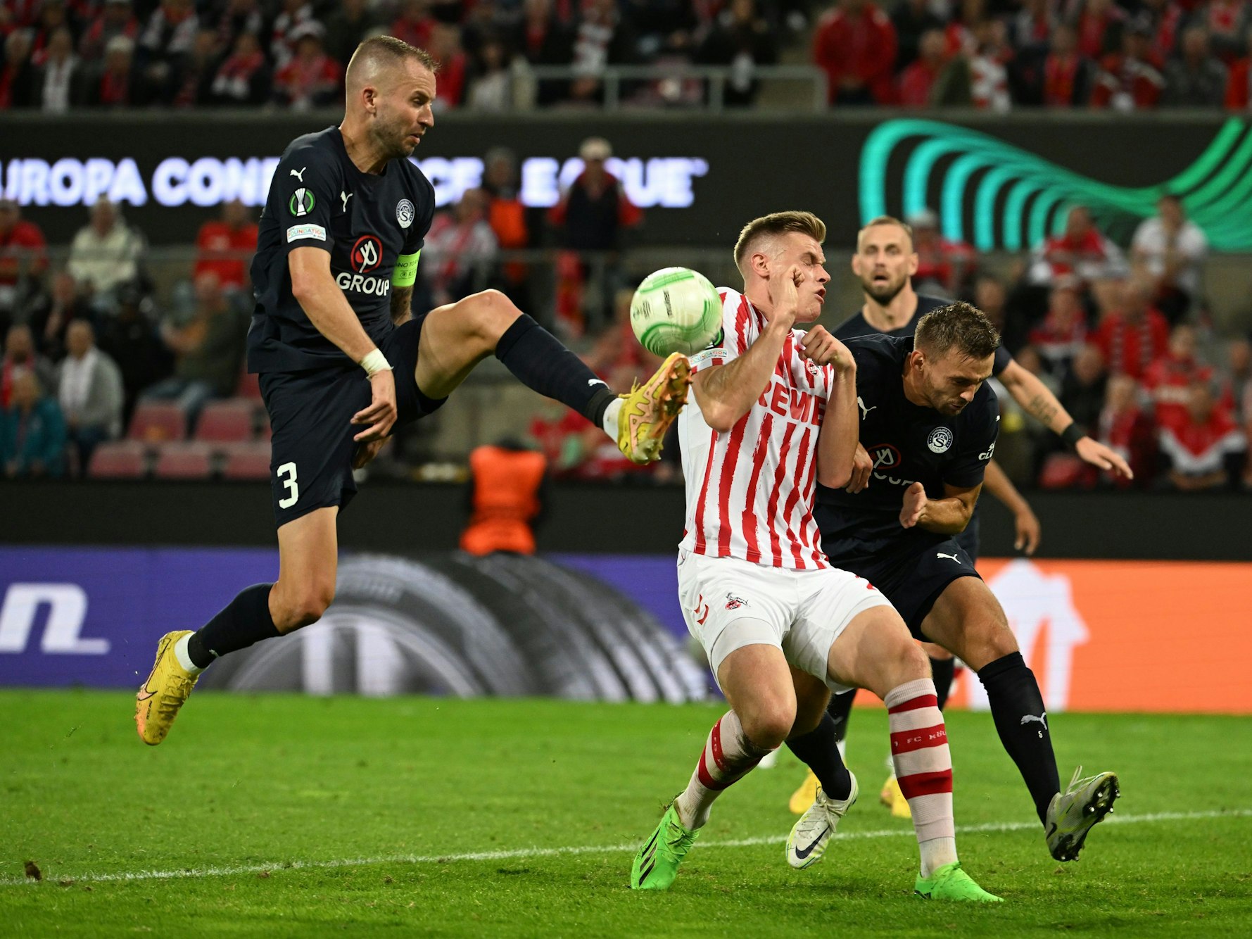 UEFA Europa Conference League im RheinEnergieStadion. Kölns Steffen Tigges (M) und Slovackos Michal Kadlec (l) versuchen den Ball zu spielen.