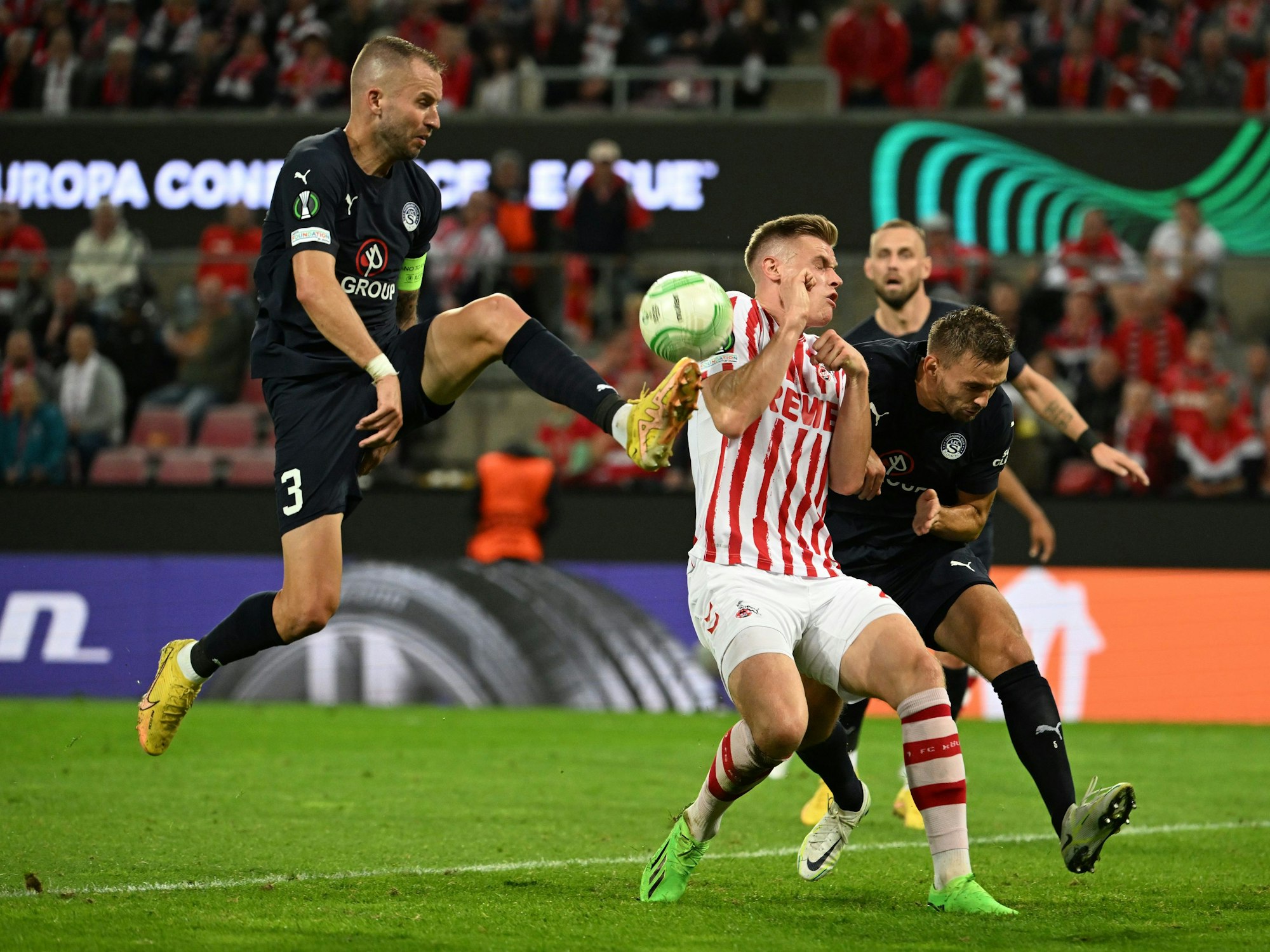 UEFA Europa Conference League im RheinEnergieStadion. Kölns Steffen Tigges (M) und Slovackos Michal Kadlec (l) versuchen den Ball zu spielen.