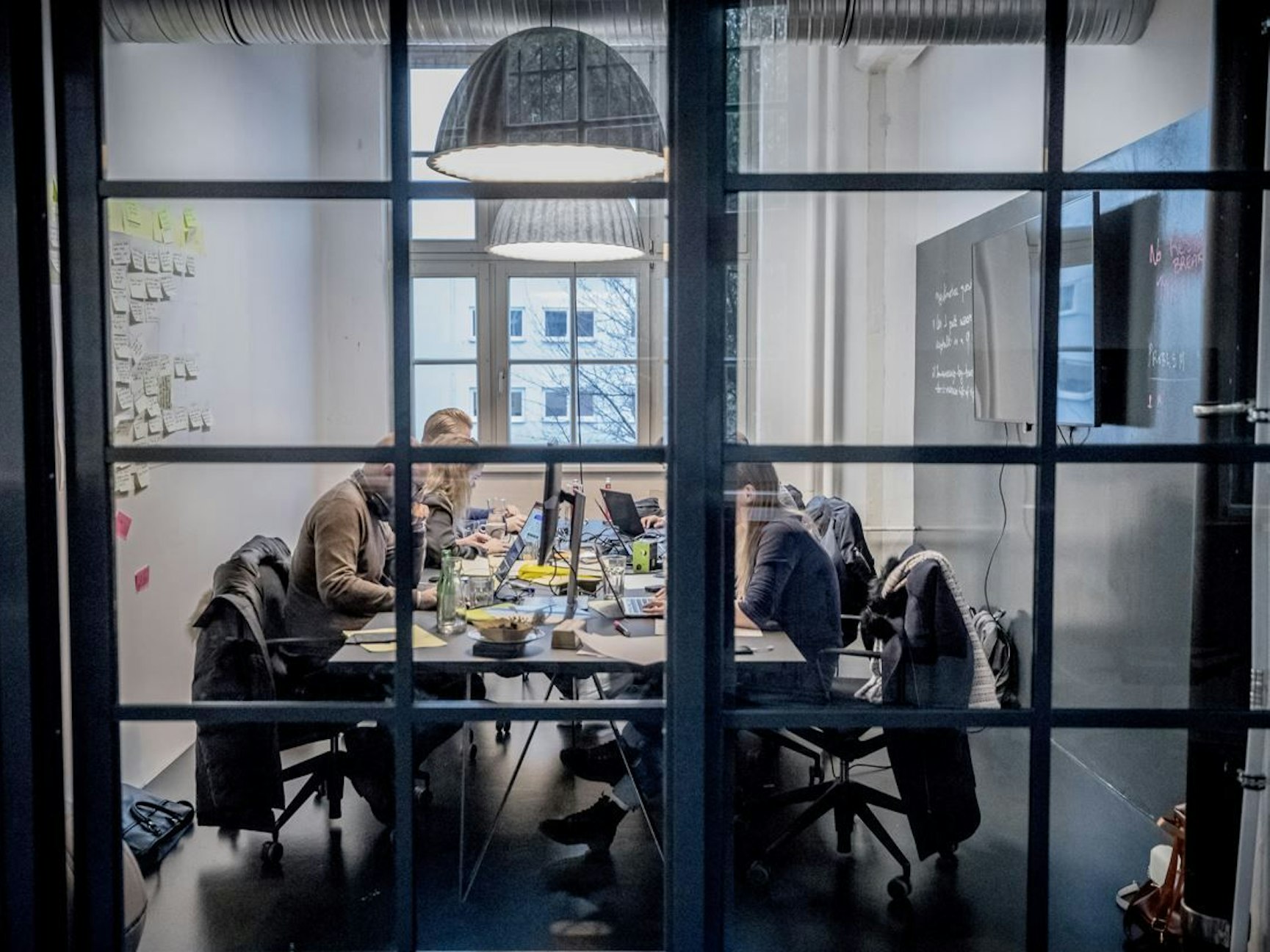 Blick durch ein Fenster. Eine Arbeitsgruppe in Berlin arbeitet an der Digitalisierung der Wohngeld-Anträge.