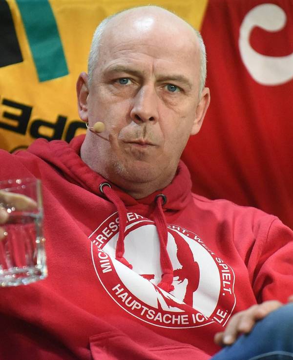 Mario Basler hält ein Wasserglas in der Hand.