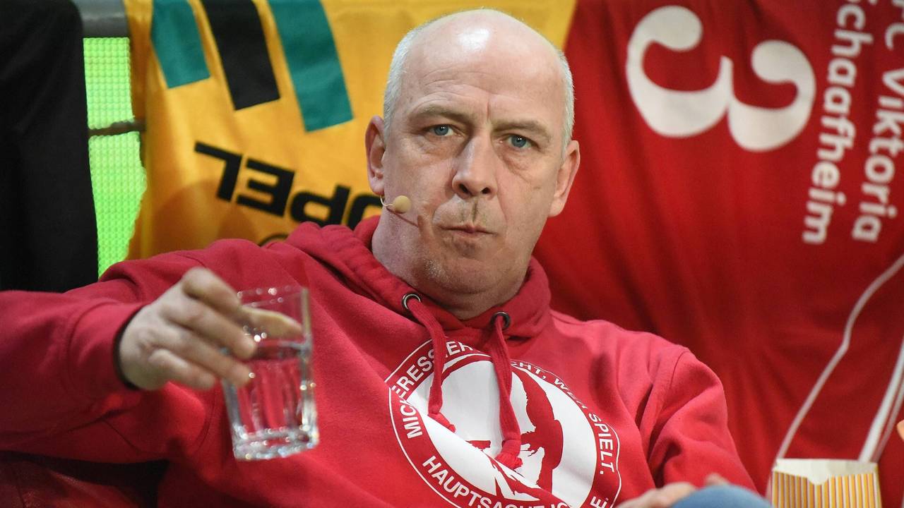 Mario Basler hält ein Wasserglas in der Hand.