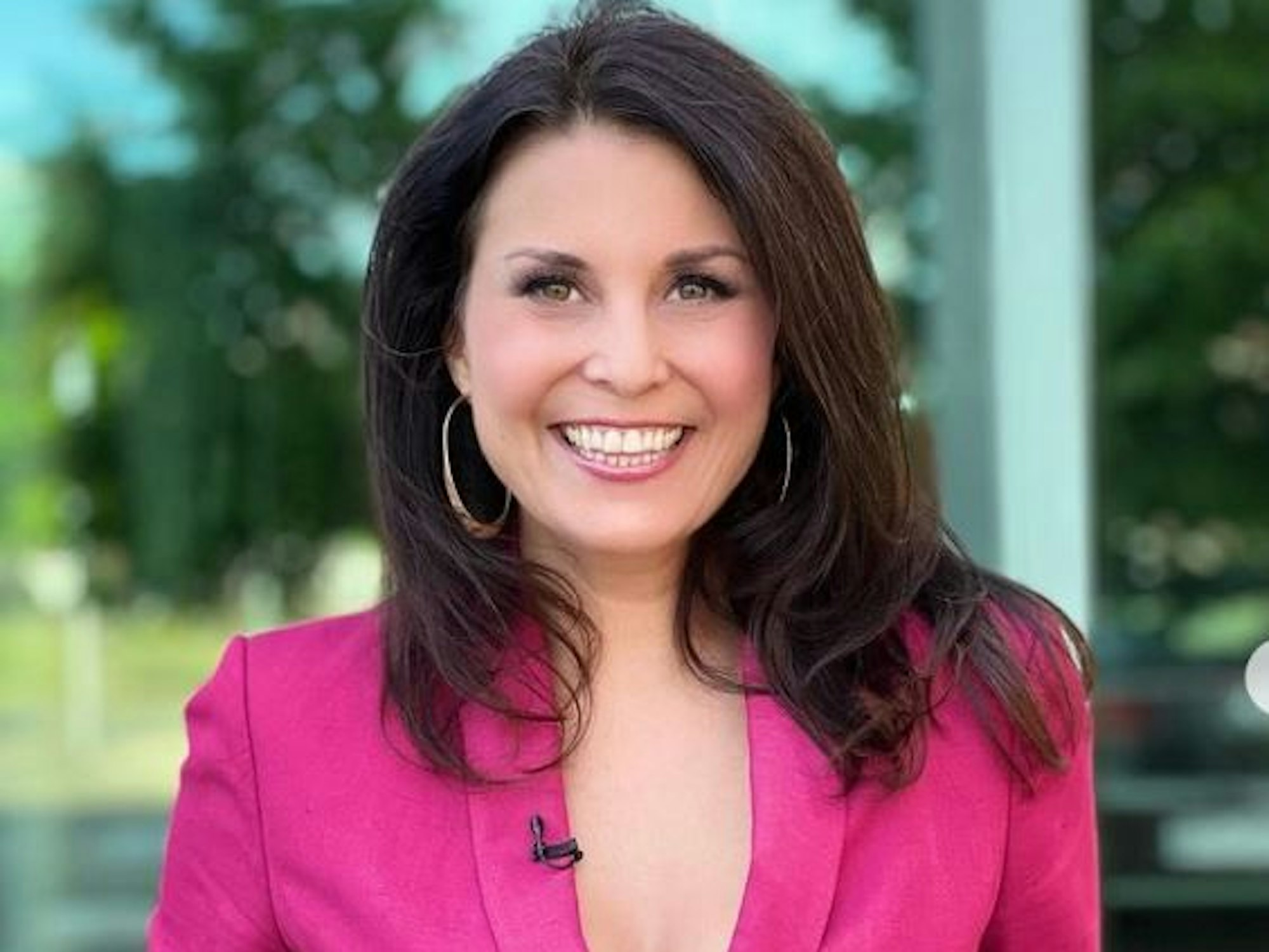 Vanessa Blumhagen strahlt in einem pinken Einteiler fröhlich in die Kamera.