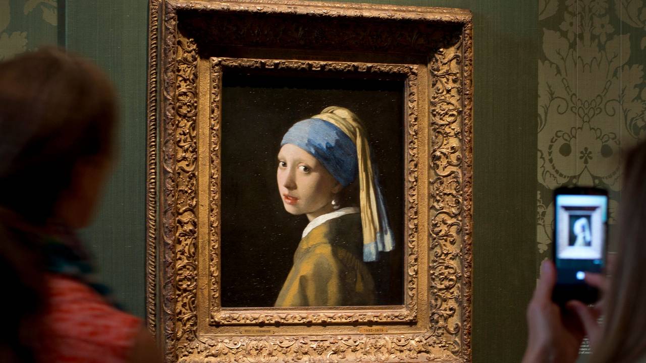 Besucher fotografieren das Gemälde „Das Mädchen mit dem Perlenohrgehänge“ des niederländischen Malers Johannes Vermeers im Mauritshuis in Den Haag.
