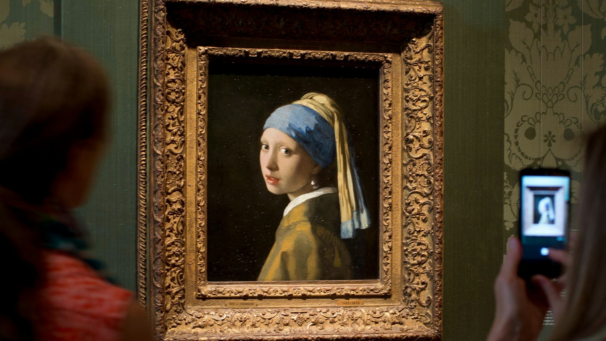 Besucher fotografieren das Gemälde „Das Mädchen mit dem Perlenohrgehänge“ des niederländischen Malers Johannes Vermeers im Mauritshuis in Den Haag.