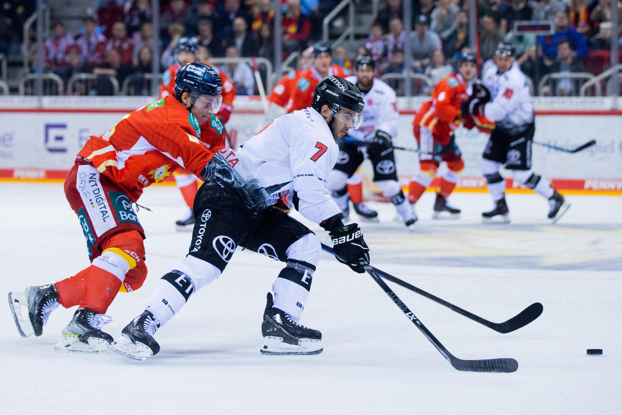 Düsseldorfs Josef Eham (l) und Kölns Nicholas Bailen versuchen an den Puck zu kommen.