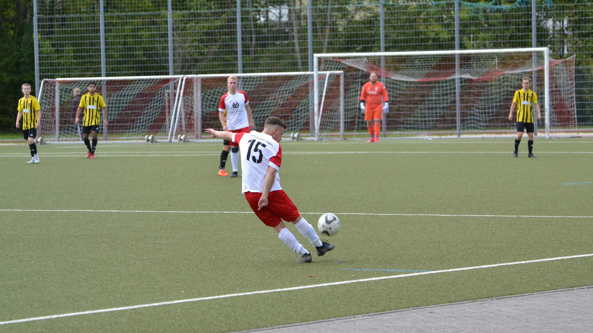 Ein Spieler schießt den Ball in Richtung des gegnerischen Tores.