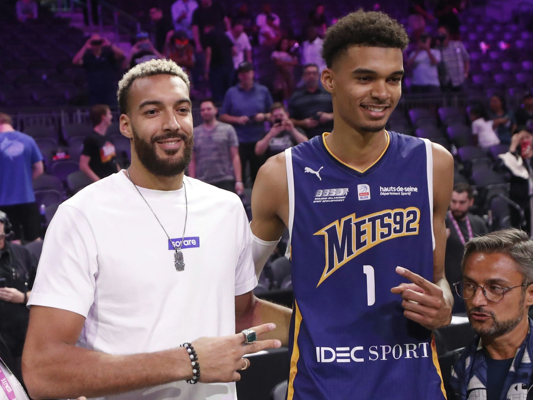 Rudy Gobert und Victor Wembanyama posieren in einer Basketball-Halle für ein Foto.