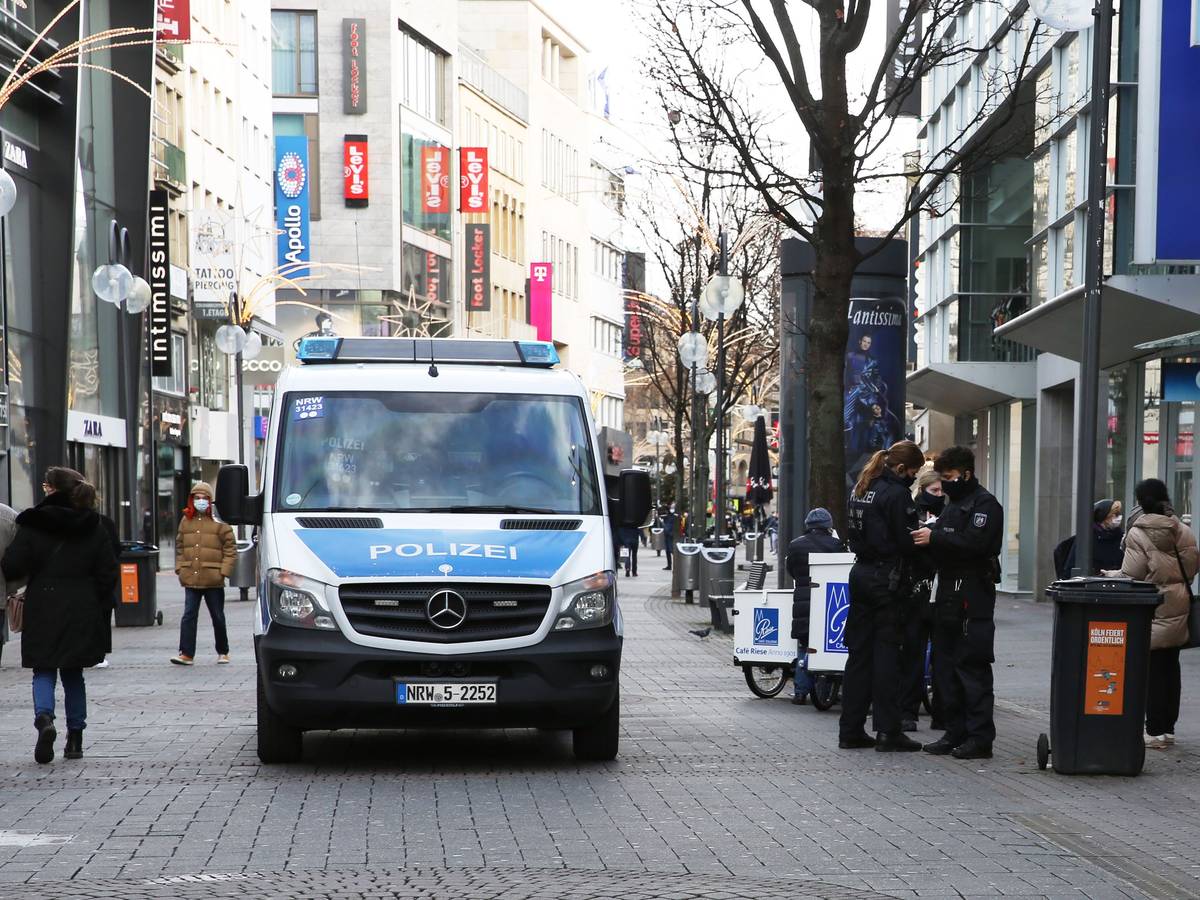 Einsatzkräfte und ein Auto der Polizei stehen auf der Schildergasse in Köln.