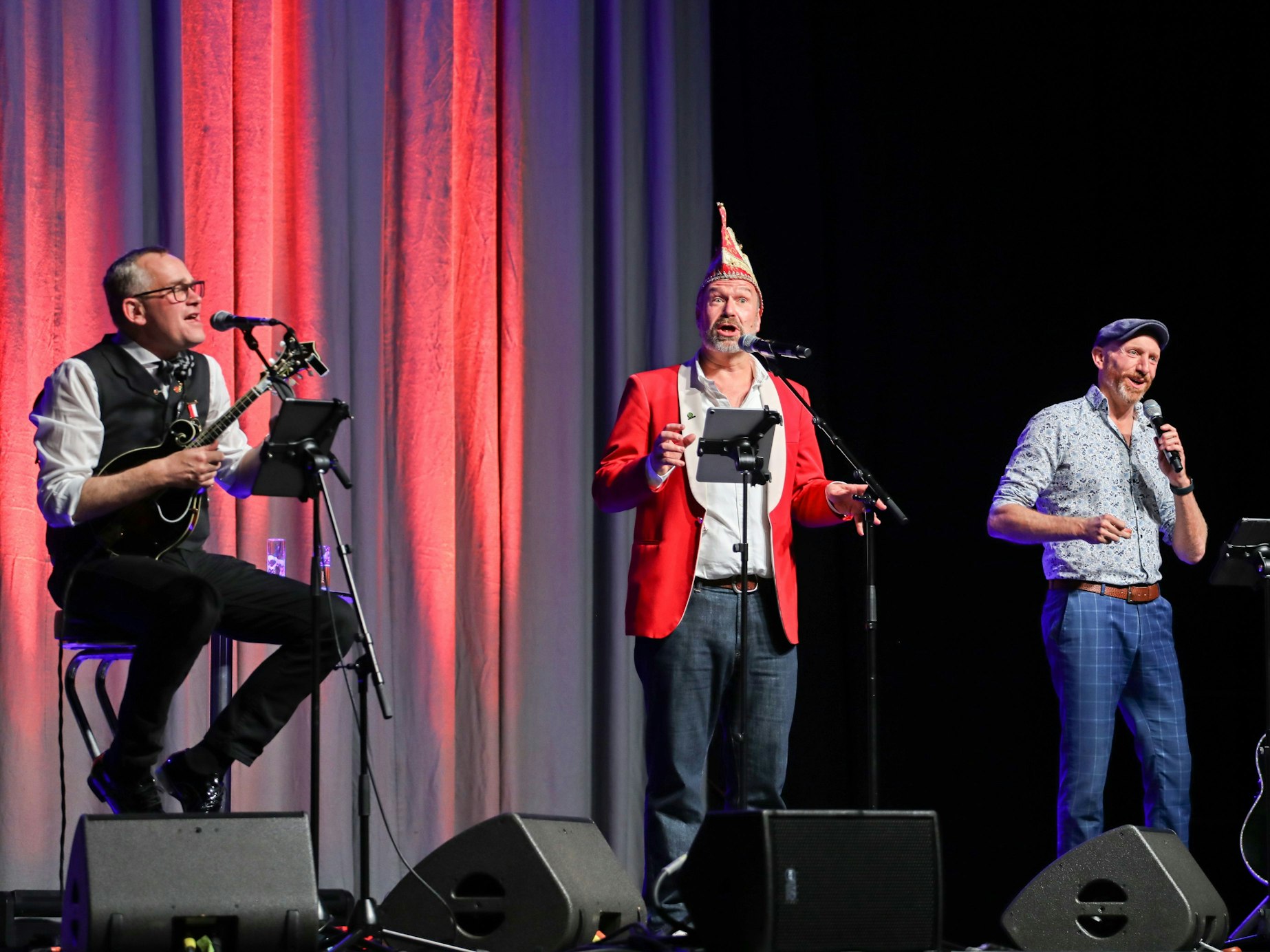 JP Weber, Volker Weininger und Martin Schopps gemeinsam auf der Bühne mit Gitarre und Mikrofonen.