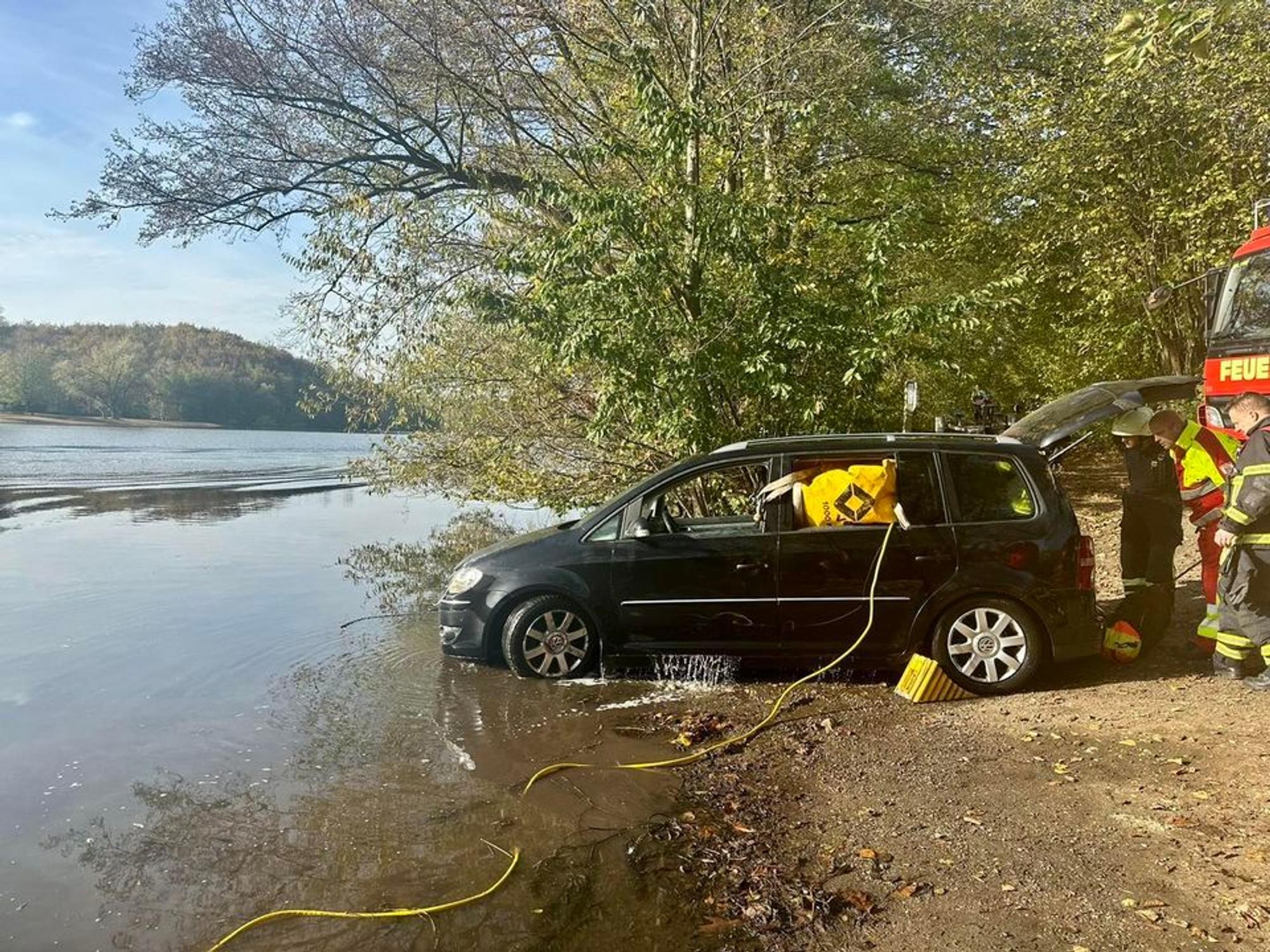 Ein Auto steht am Ufer eines Sees.