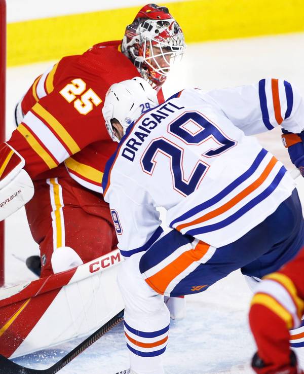 Edmonton Oilers Leon Draisaitl (r.) legt Puck an Calgary-Flames-Keeper Jacob Markstrom vorbei ins Tor.