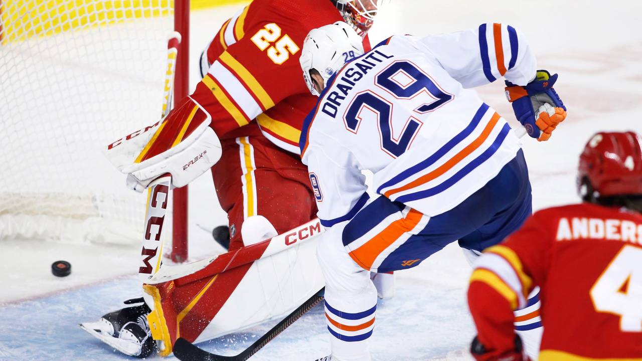 Edmonton Oilers Leon Draisaitl (r.) legt Puck an Calgary-Flames-Keeper Jacob Markstrom vorbei ins Tor.