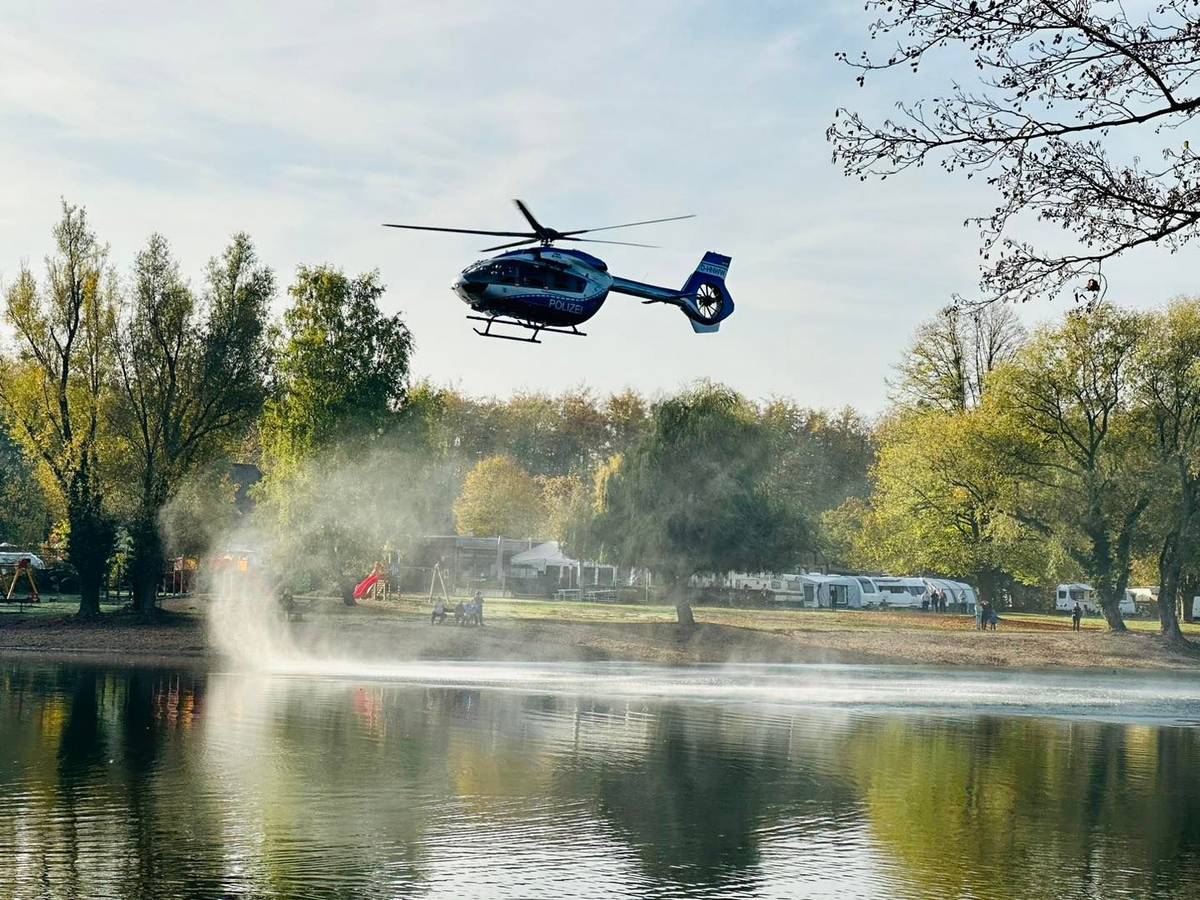 Ein Hubschrauber fliegt über einen See.