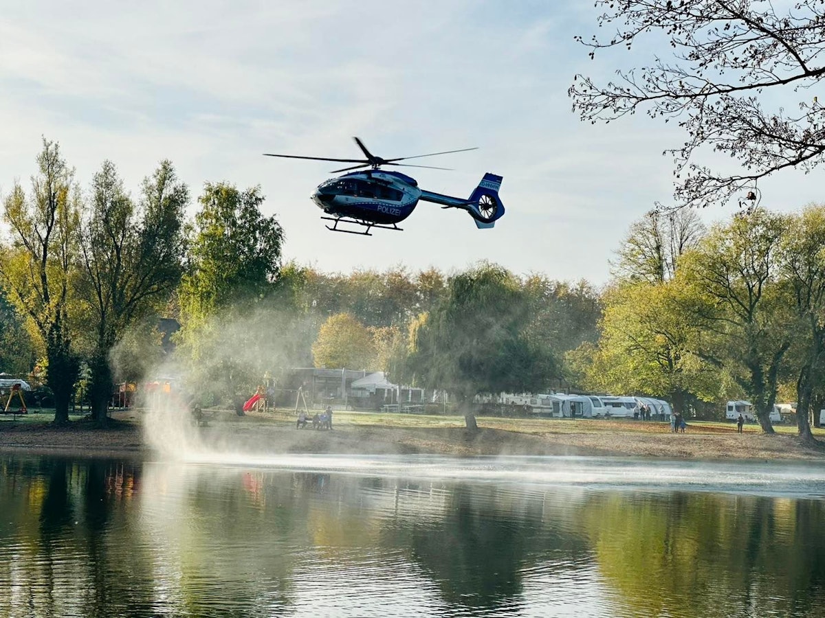 Ein Hubschrauber fliegt über einen See.