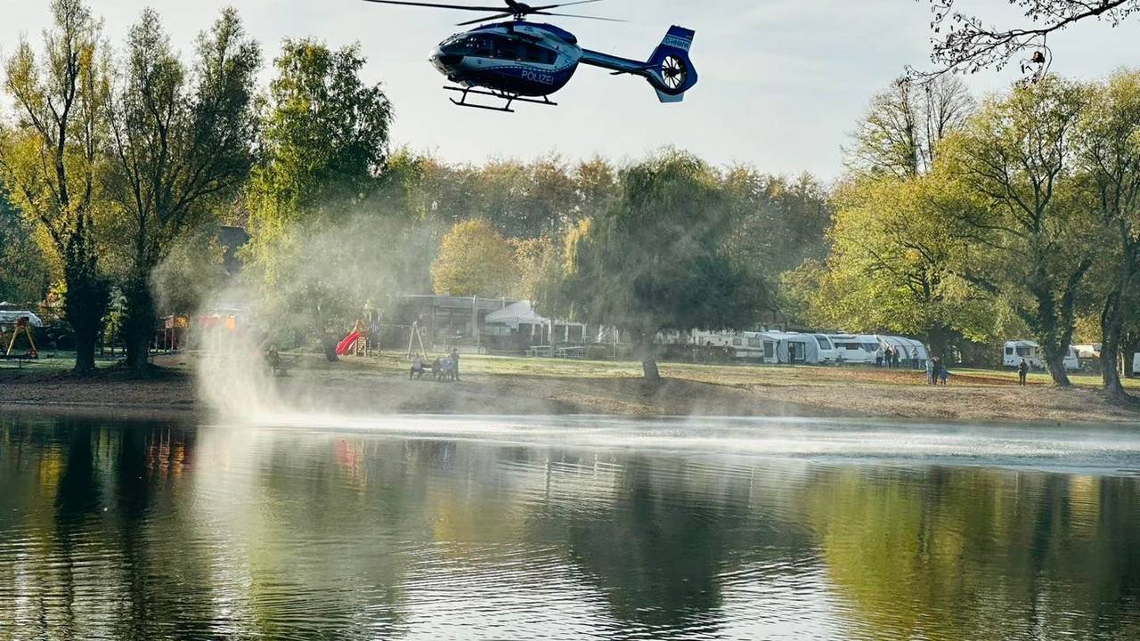 Ein Hubschrauber fliegt über einen See.